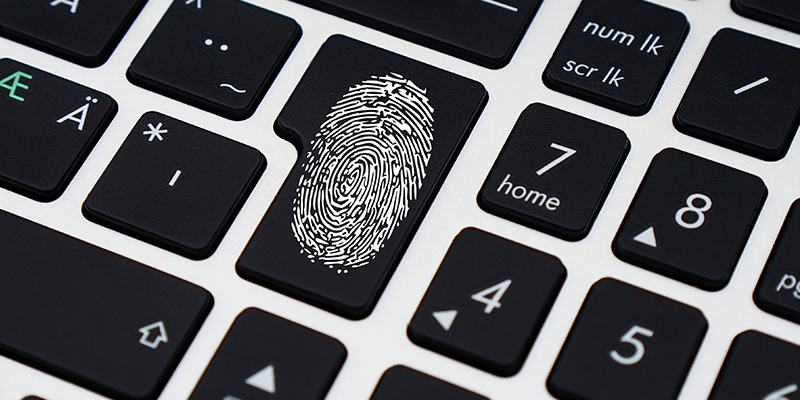 closeup of computer keyboard with black keys and a white fingerprint on the